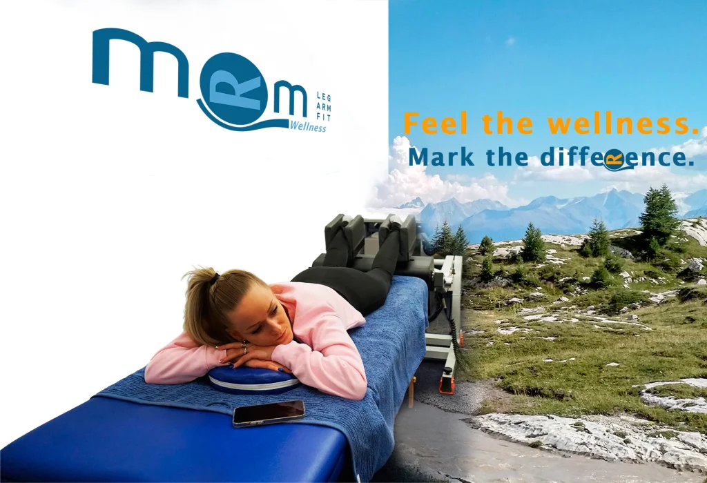 Person lying on a treatment table using the MRM Wellness device, with a mountainous landscape in the background and the slogan “Feel the wellness. Mark the difference.”